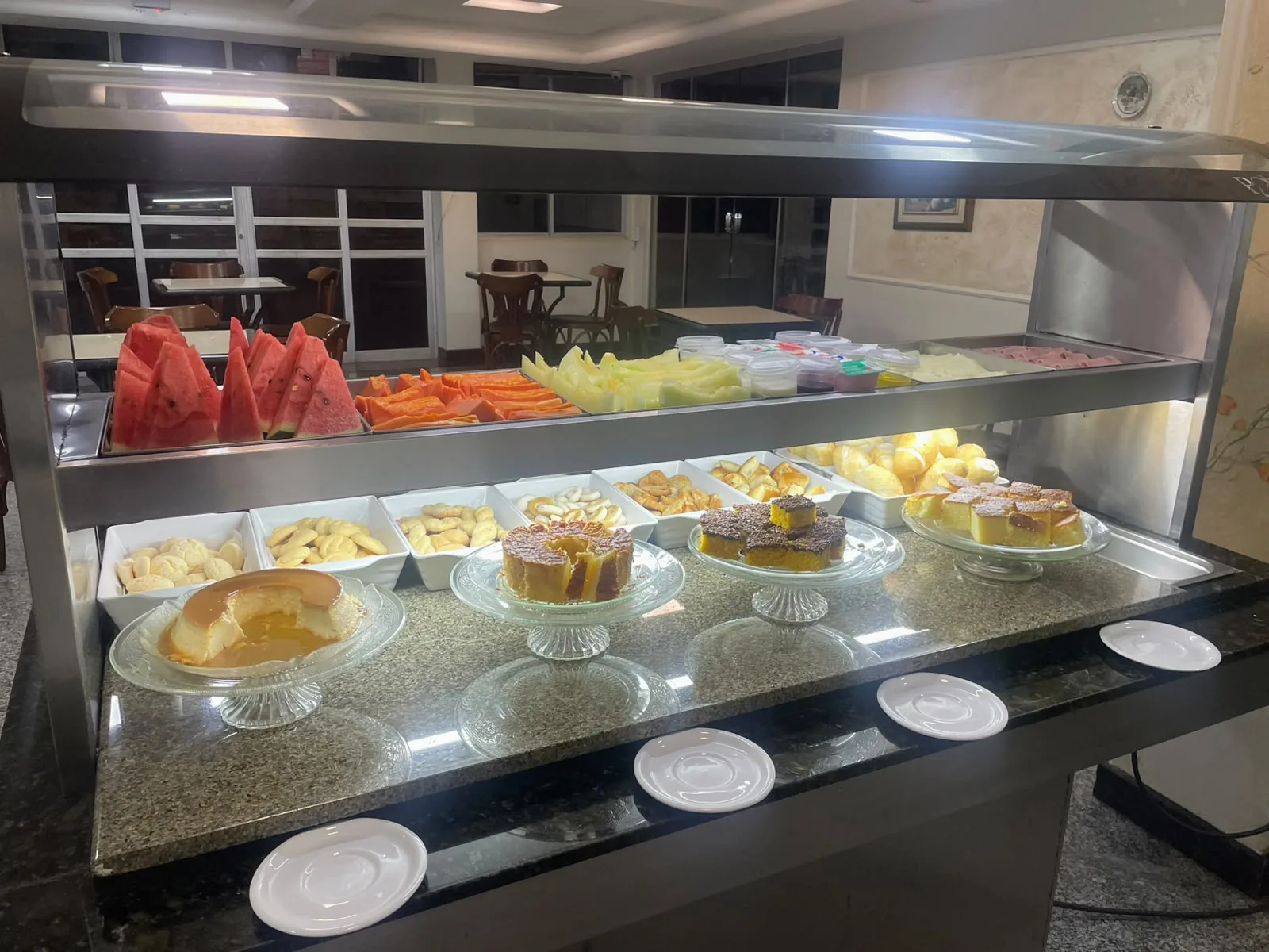 Vitrine do café da manhã do Hotel Apollo, com o salão ao fundo