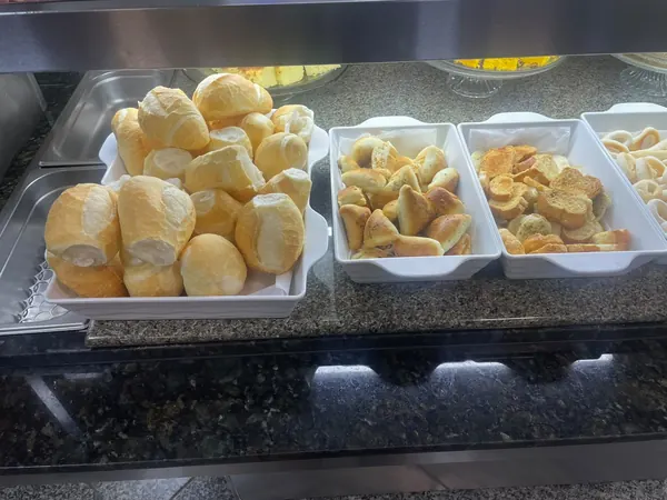 Pães e pão de queijo nas cubas do buffet do café da manhã