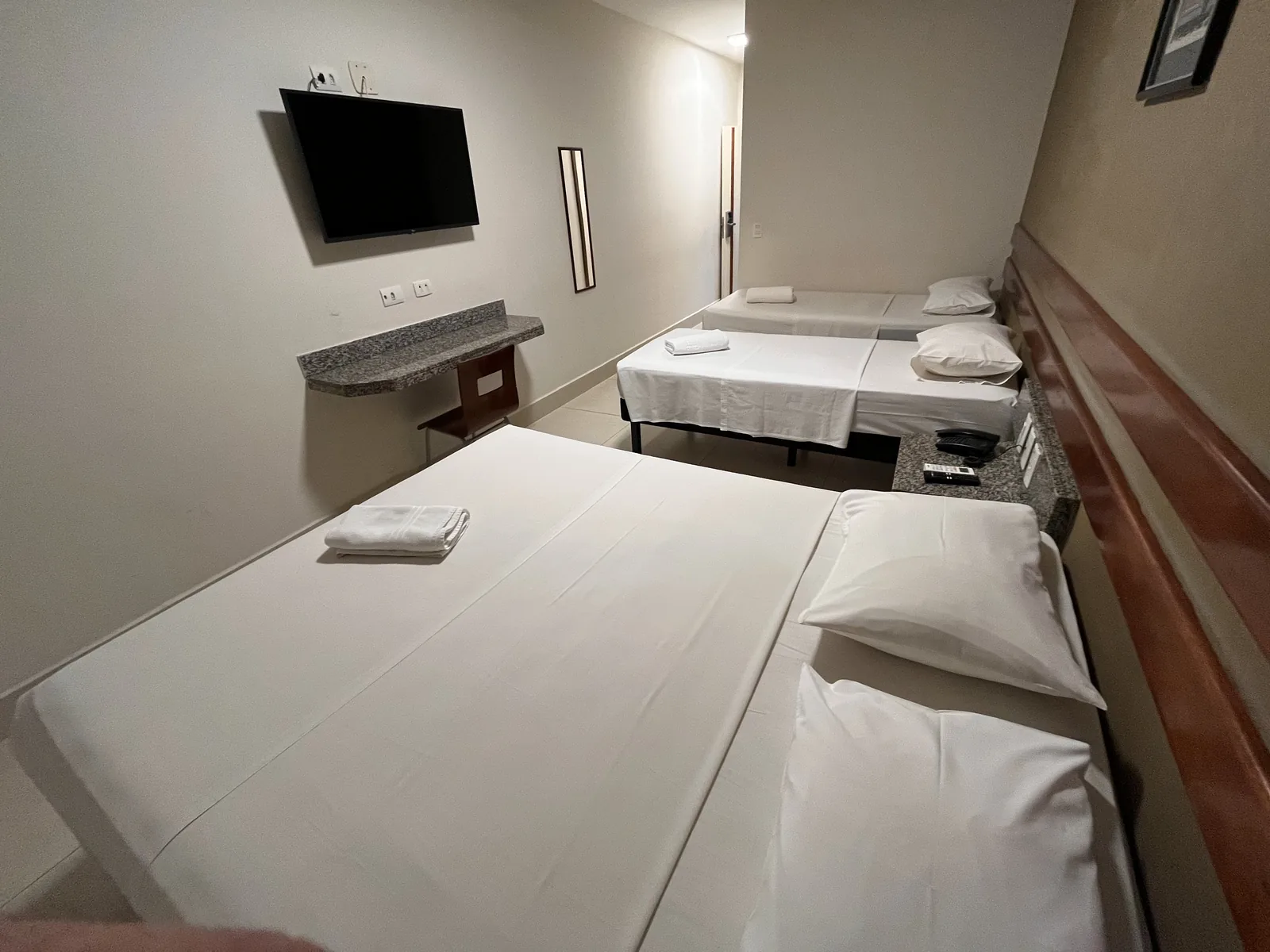 Apartamento quádruplo do Hotel Apollo, com televisão na parede